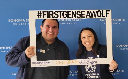 Photo of two first-generation Sonoma State Staff holding up a photo frame that says #firstgenseawolf